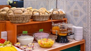 A breakfast buffet with various bread, fruit, and beverages. - Hotel Mala Strana (Prague)