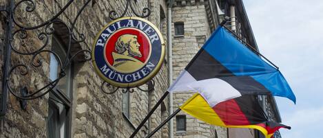Un edificio con un letrero que dice "PULANER MUNICH" y una bandera.