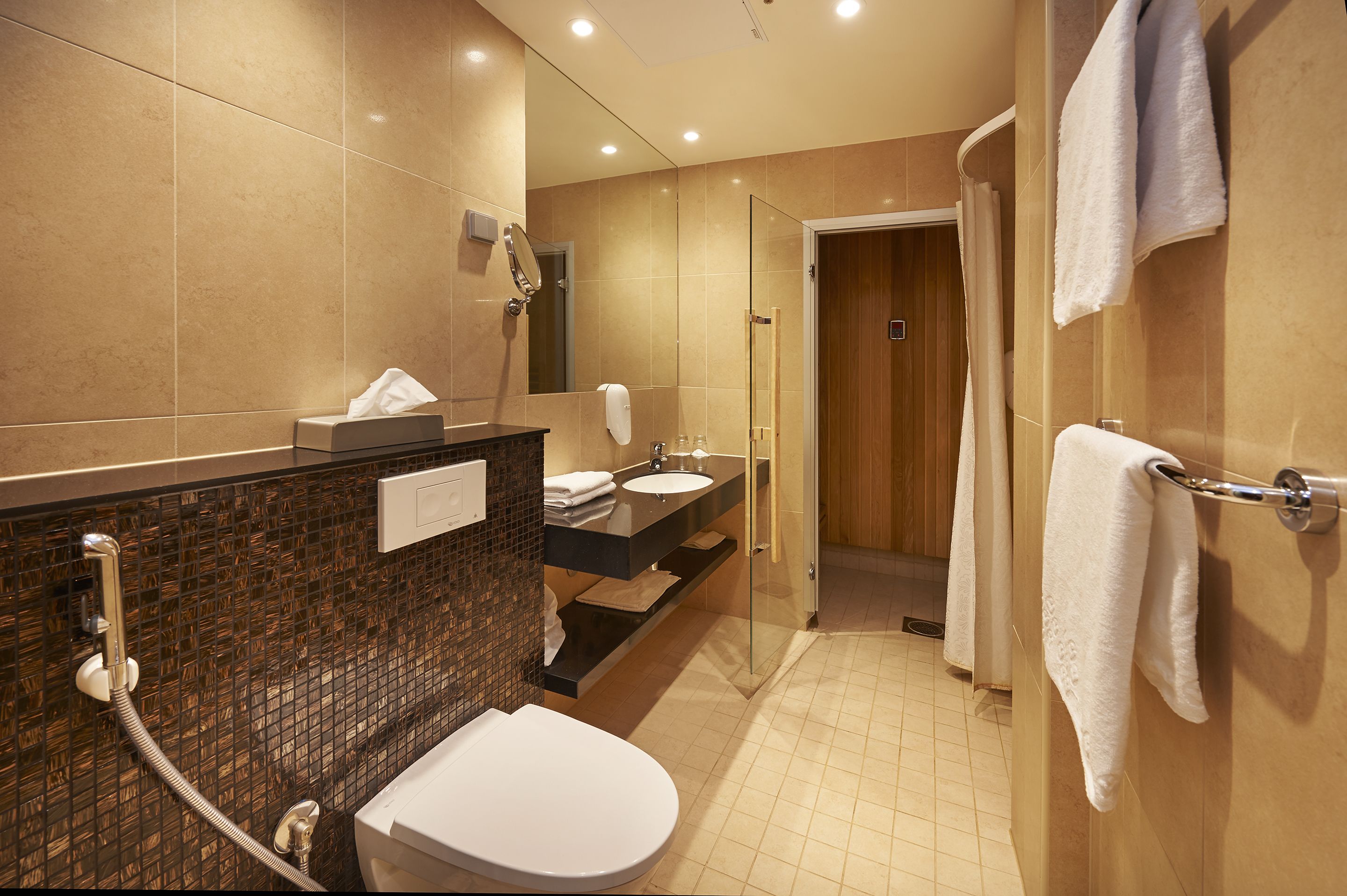 Une salle de bain moderne avec une douche à parois de verre, des toilettes, un lavabo avec un meuble-vasque et un porte-serviettes.