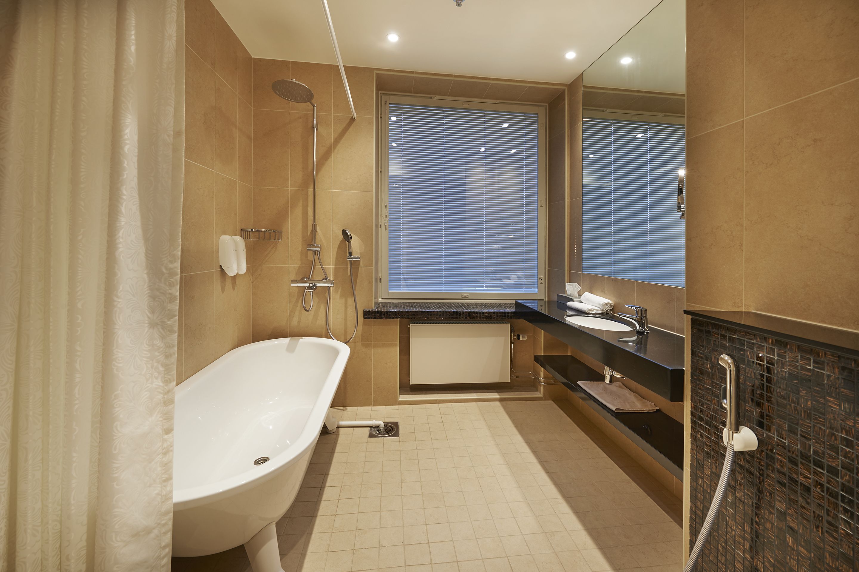 A modern bathroom with a freestanding bathtub, a vanity with a sink, and a shower area.