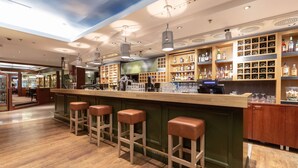 A bar area with stools, shelves of bottles, and a counter. - Scandic Atlas (Kuopio)