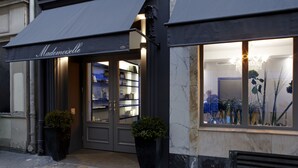 Un escaparate con un toldo oscuro y el nombre 'Mademoiselle'.