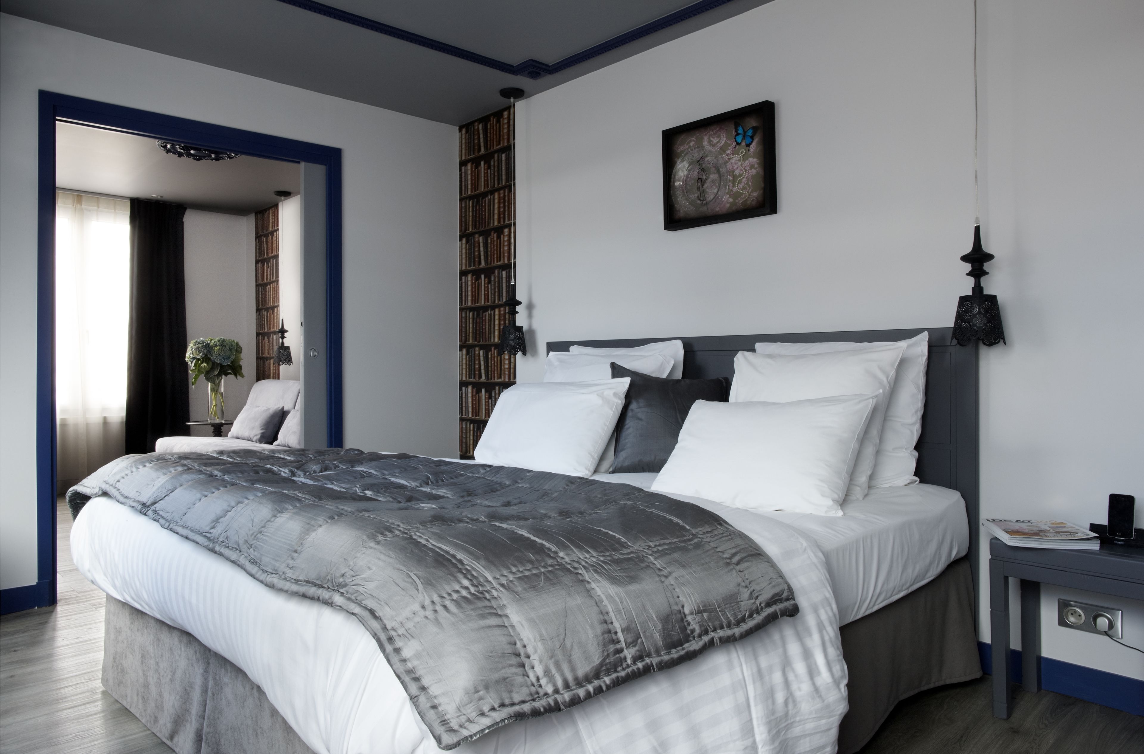 Ein Schlafzimmer mit Bett, Nachttisch und Bücherregal.