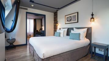 Une chambre moderne avec un grand lit, des tables de chevet, une armoire et une bibliothèque.