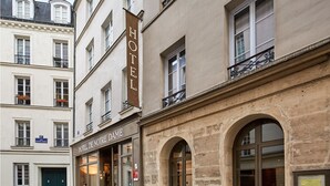 Fachada de hotel con un letrero que dice "HOTEL DE NOTRE DAME" y una puerta de entrada visible.
