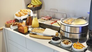 A buffet with various food items including pastries, fruits, and a hot pot. - Nouvel Hotel Eiffel (Paris)
