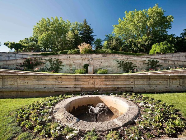 Stroll through a serene garden oasis, surrounded by lush greenery and a tranquil water feature.