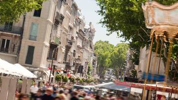 Una calle concurrida, edificios históricos, un carrusel y una multitud de gente.