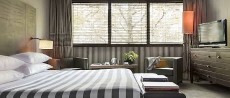 Deluxe kamer | Luxe beddengoed, een minibar, een kluis op de kamer, een bureau