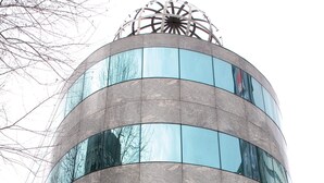 A building with a curved facade, the name "ZEBRA SQUARE" prominently displayed, and a decorative element on top.