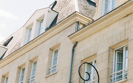 A building with multiple windows, a street lamp, and a sign reading "Alfred Hotels."