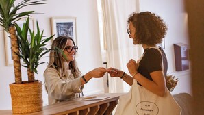 Een receptie met een houten balie, een potplant en kunstwerken in lijsten aan de muur.