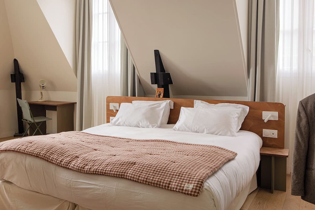 Una habitación de hotel con una cama, un escritorio y una silla.