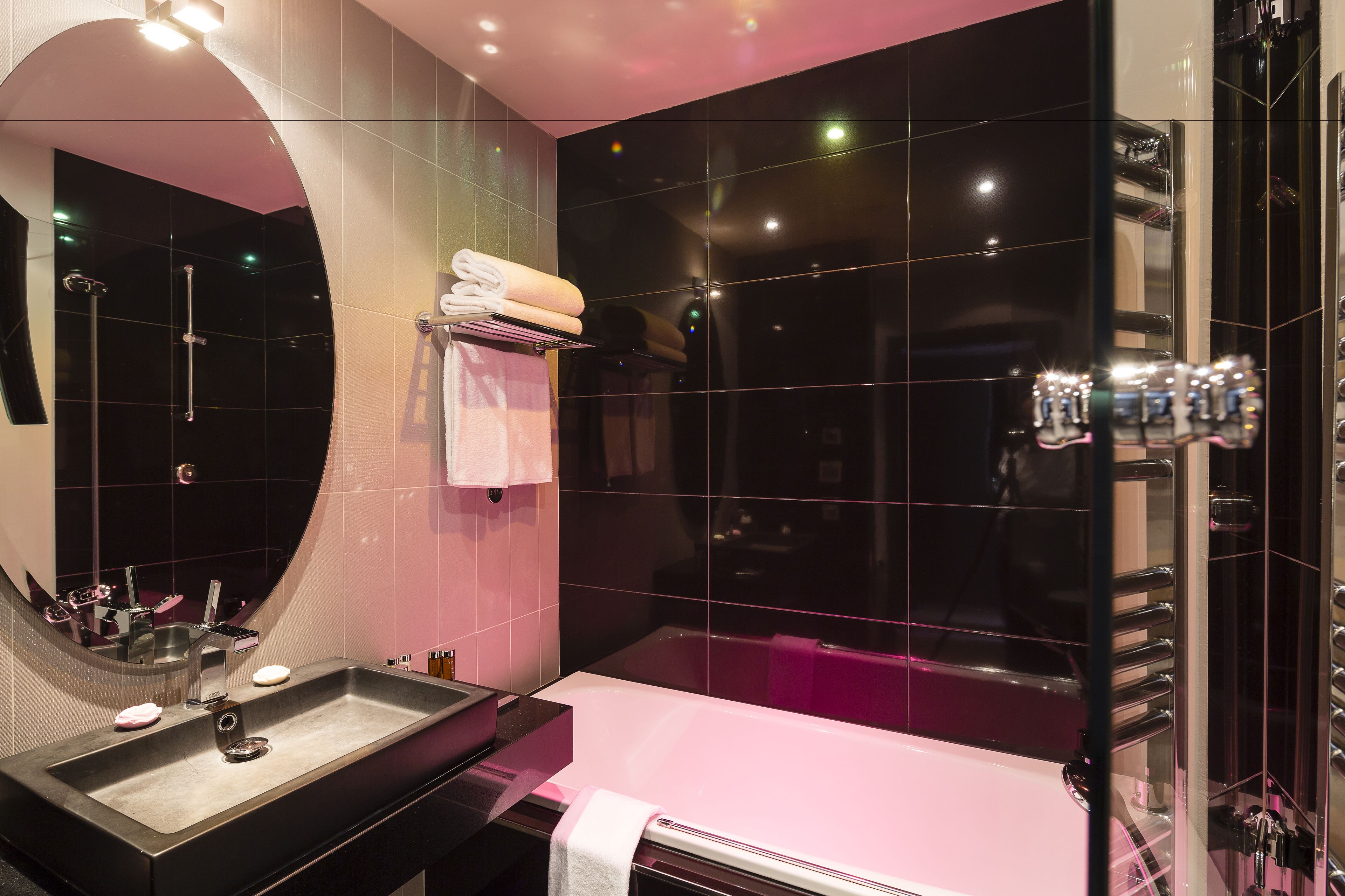 Un baño moderno con un espejo grande, un lavabo, una bañera y una ducha.