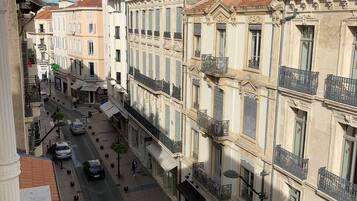 Vista de una calle en un pueblo histórico europeo, con arquitectura tradicional, balcones ornamentados y fachadas clásicas.