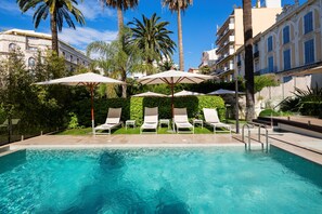 Piscine extérieure, parasols de plage, chaises longues