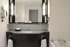 Bathroom features a sleek vanity with a granite countertop, single sink, and large mirror.
