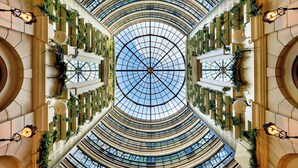 Un ampio atrio con soffitto a cupola in vetro, diversi piani e un design simmetrico.