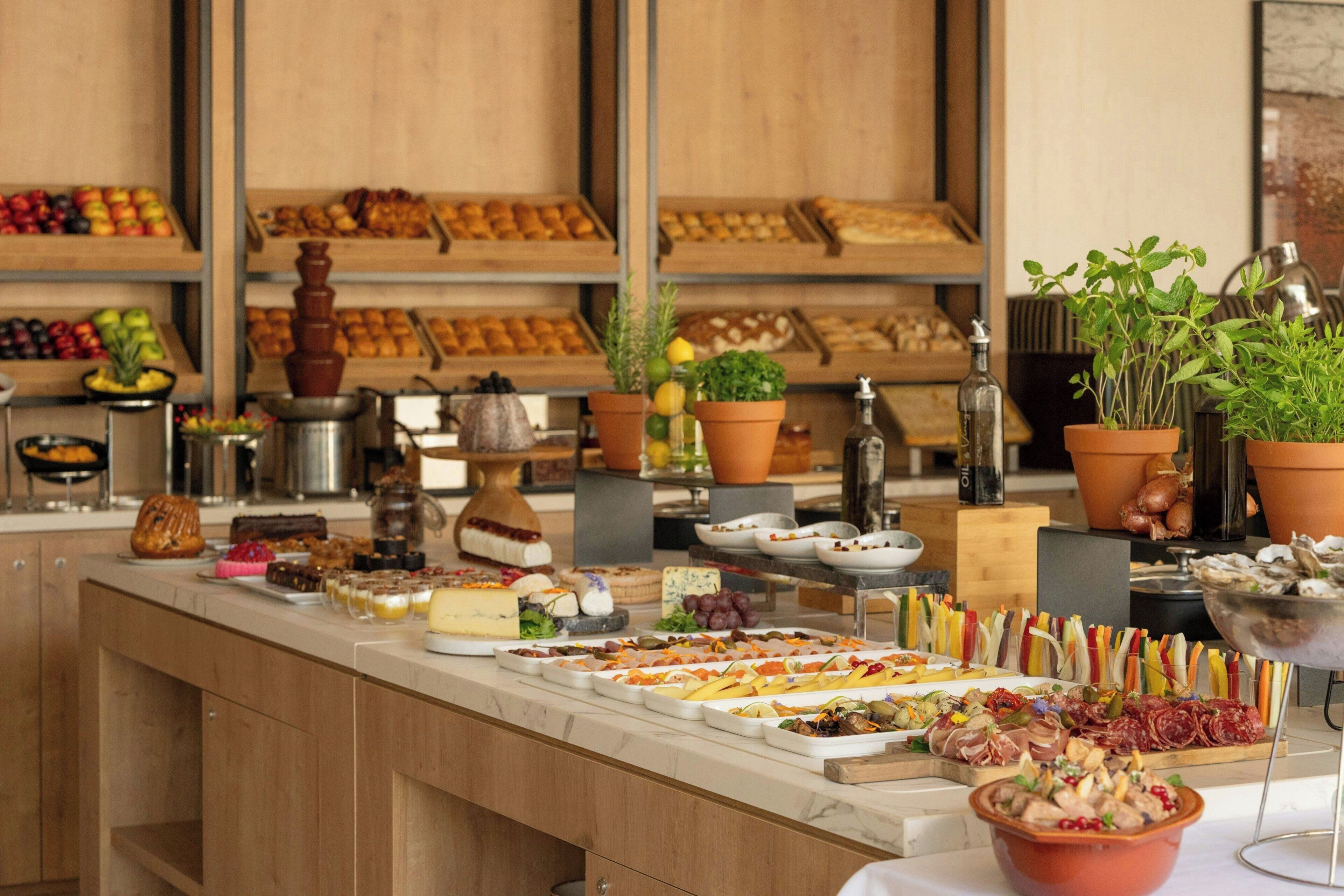 A buffet with various food items and a selection of potted plants.
