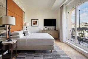 Relax in a spacious room with a large bed, flat-screen TV, and city view.