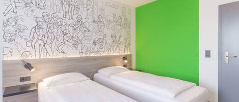 Quarto de hotel com duas camas, uma parede verde e um mural de pessoas na parede.
