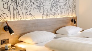 A modern hotel room with a wooden headboard, white bedding, and a wall mural. - ibis Styles Halle (Halle (Saale))