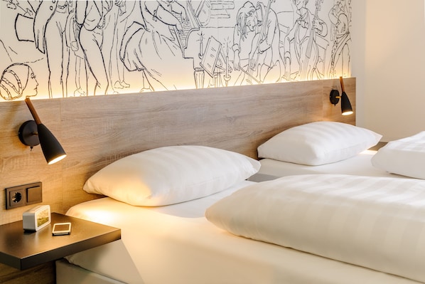 A modern hotel room with a wooden headboard, white bedding, and a wall mural. - Sunday Hotel Halle Zentrum (Halle (Saale))