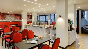 A modern restaurant with red chairs and tables, a central island with food and drinks, and a decorative wall mural. - ibis Styles Halle (Halle (Saale))