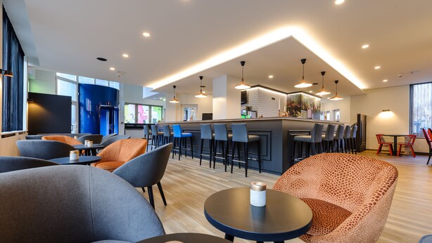 A modern bar area with seating and a counter. - ibis Styles Halle (Halle (Saale))