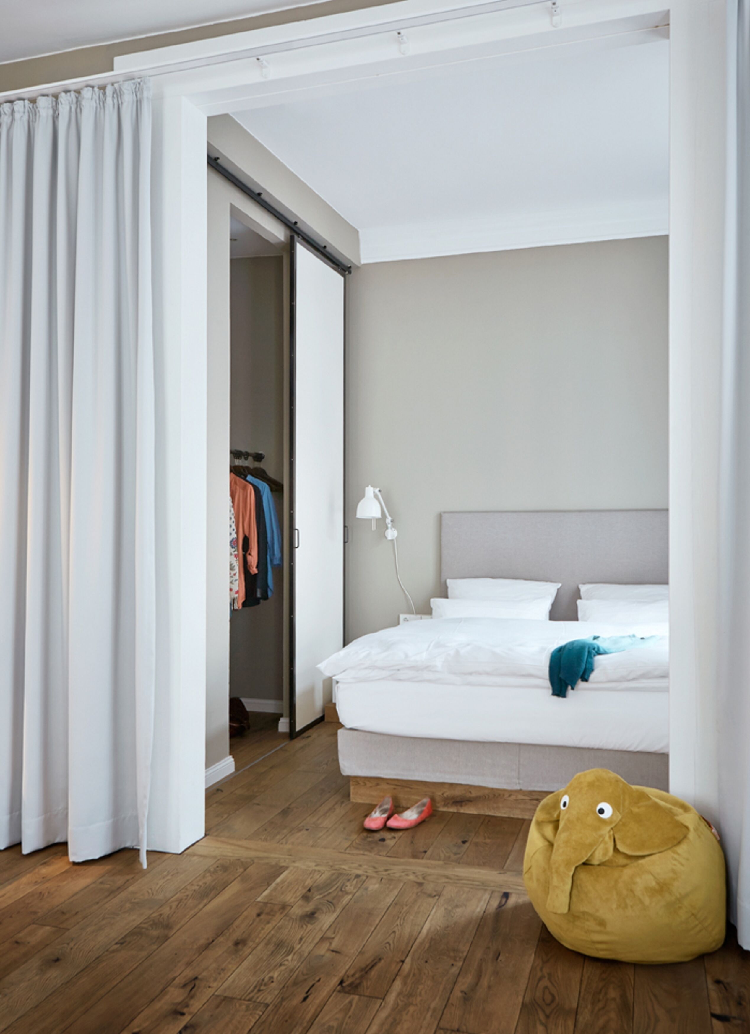 Un dormitorio con una cama, un armario y piso de madera.