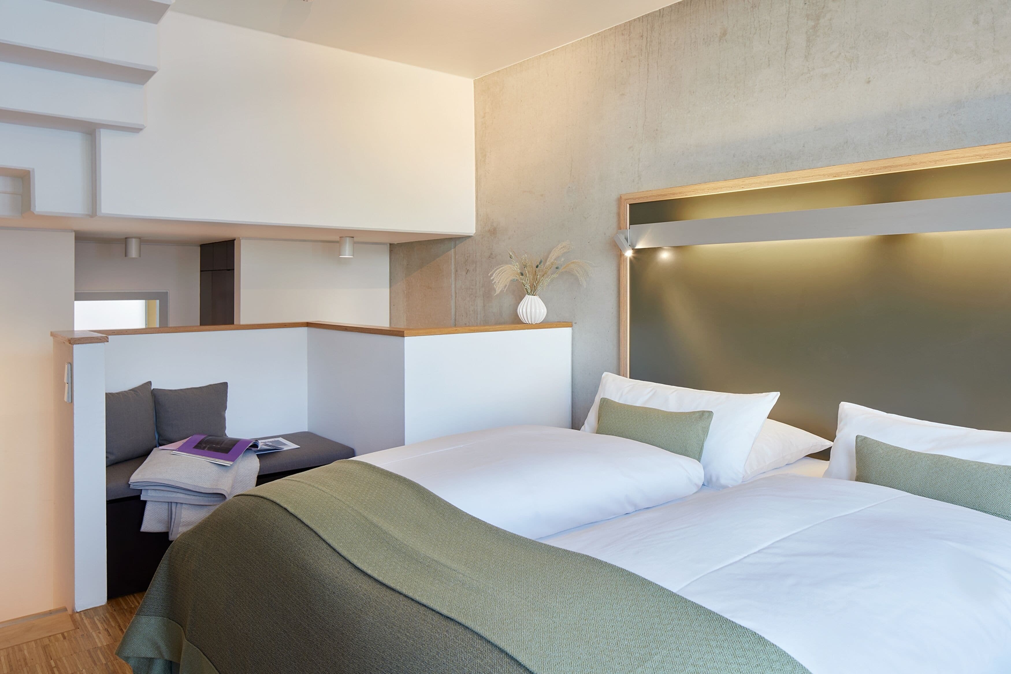 Une chambre d’hôtel moderne dotée d’un grand lit, d’un bureau avec une chaise et d’un petit coin salon.