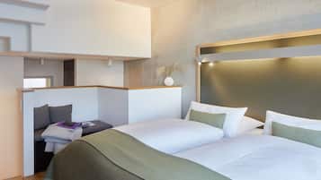 Une chambre d’hôtel moderne dotée d’un grand lit, d’un bureau avec une chaise et d’un petit coin salon.