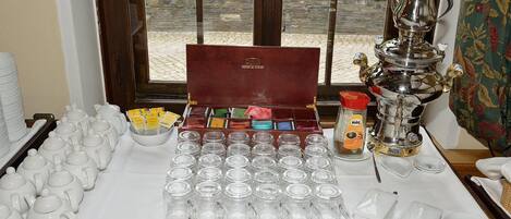 Un juego de té dispuesto sobre una mesa, con teteras, tazas y un samovar.