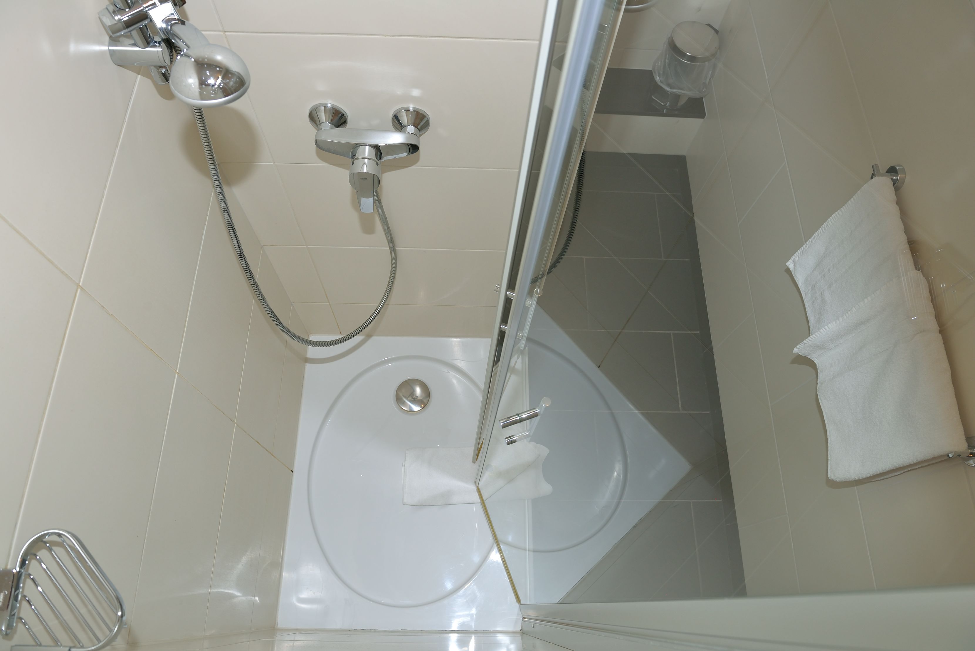 Un baño con ducha, inodoro y perchero para toallas.