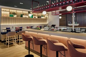 A modern bar area with seating, a bar counter, and a wine display. - Leipzig Marriott Hotel (Leipzig)