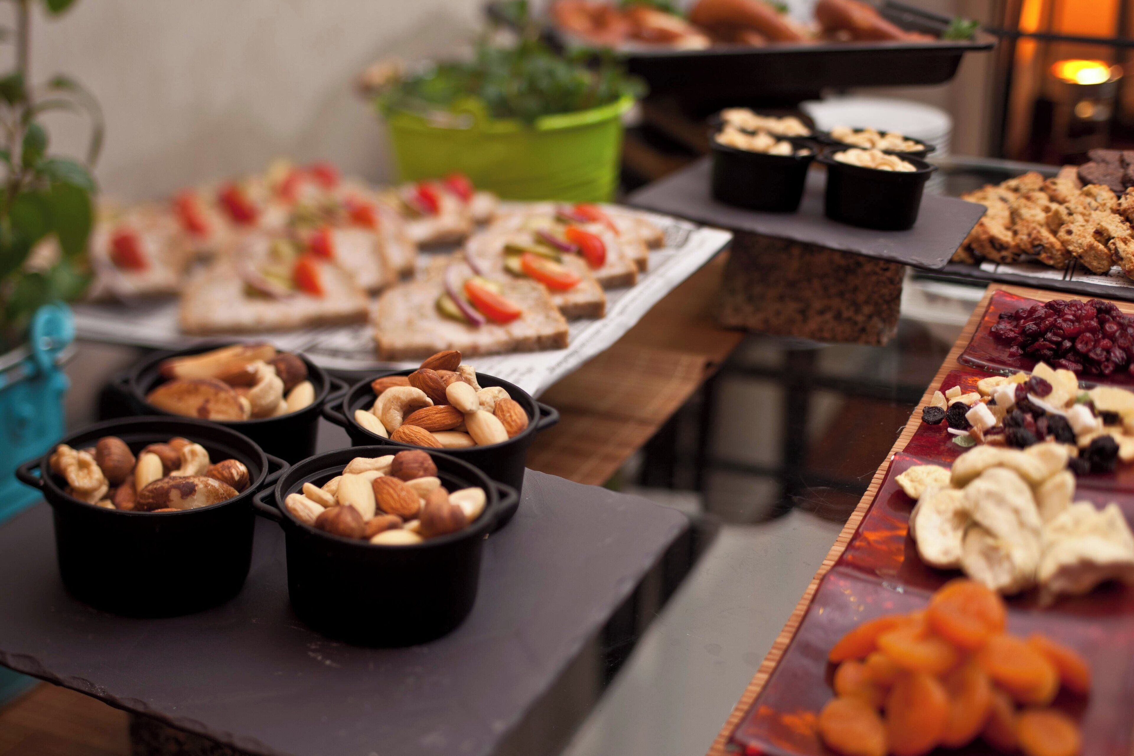 A buffet with various food items including nuts, pastries, and fruits.