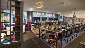 A modern hotel lobby with a long bar area, seating arrangements, and large windows offering views of the cityscape. - Leipzig Marriott Hotel (Leipzig)