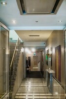 Un pasillo de hotel con una puerta de cristal, una escalera y un piso de baldosas.
