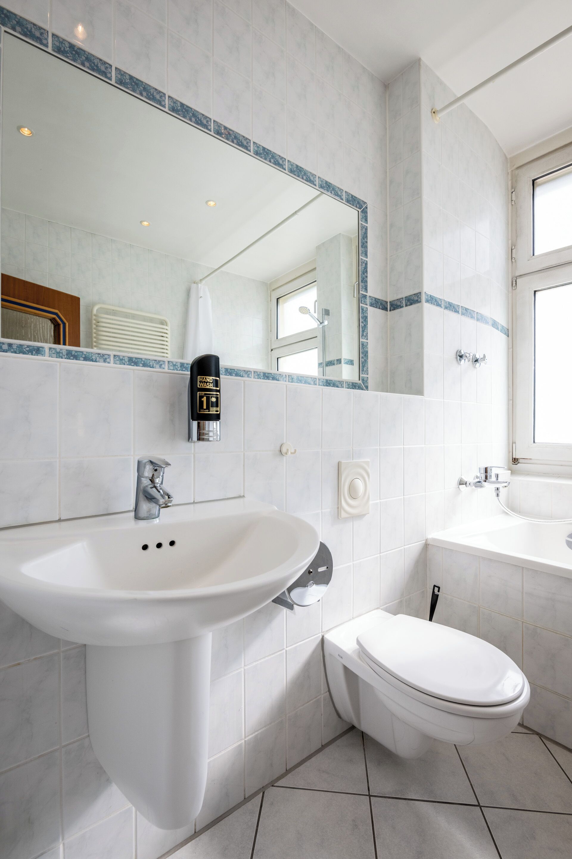 A modern bathroom with a white sink, toilet, and vanity.