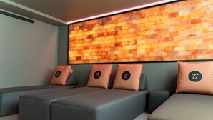 A modern relaxation area with cushioned seating and a large wall-mounted screen. - Hotel Am Triller (Saarbrücken)