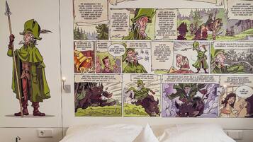 A bedroom with a large mural depicting a comic strip titled "Der Moldiss im Köllertal" on the wall.