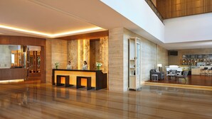 A spacious lobby with a reception desk, seating area, and a staircase leading to an upper level. - Courtyard by Marriott Bandung Dago (Bandung)