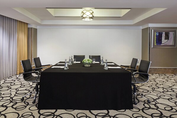 A conference room with a long table, black chairs, and a black tablecloth. - Courtyard by Marriott Bandung Dago (Bandung)