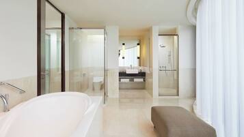 A modern bathroom with a large bathtub, a shower, and a vanity with a mirror.