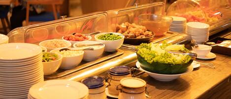 A buffet with various food items and serving utensils.
