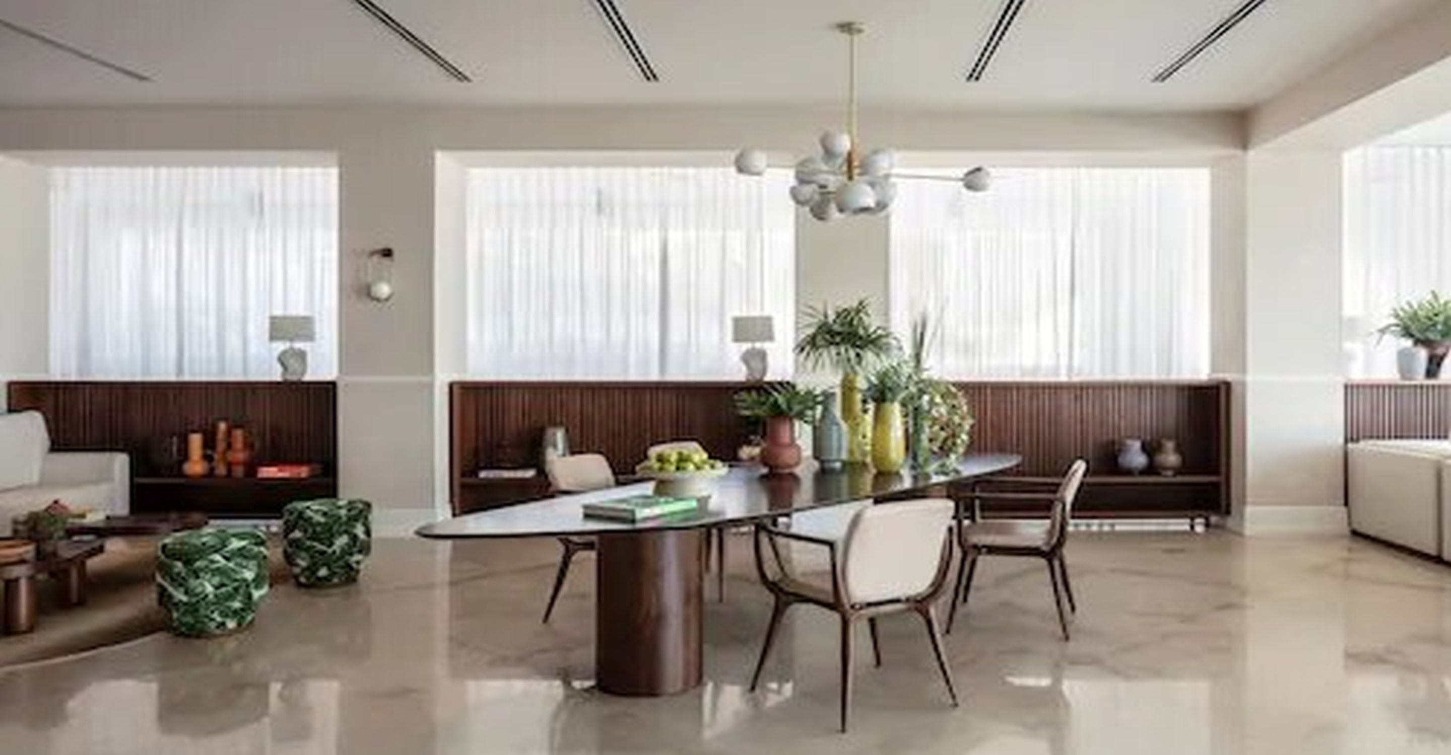Un comedor moderno con una mesa redonda, sillas y una lámpara de araña.