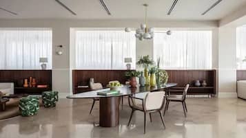 Un comedor moderno con una mesa redonda, sillas y una lámpara de araña.