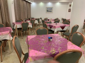A dining area with multiple tables and chairs, each covered with a pink tablecloth. - Mount Of Olives Hotel (Jerusalem)