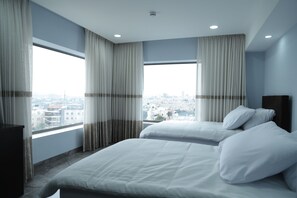 A hotel room with two beds, large windows with curtains, a city view, and a modern design. - Mount Of Olives Hotel (Jerusalem)
