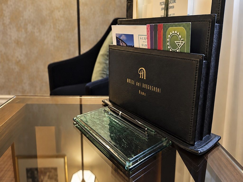 A black leather wallet with embossed text, placed on a glass table.